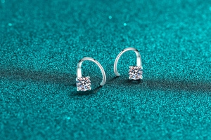 Gros plan de boucles d'oreilles en argent avec moissanite, serti quatre griffes et crochets épurés