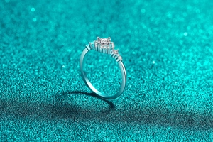 Macro shot of princess cut moissanite ring with asymmetric pavé setting on silver band