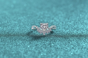 Macro shot of silver heart moissanite ring with crown-shaped diamond details