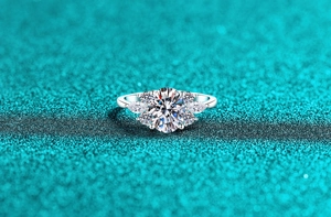 Vue macro de bague moissanite ovale avec pierres latérales sur fond scintillant