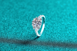 Vue macro d'une bague en argent S925 avec moissanite et diamants sur fond bleu scintillant