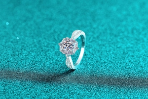 Macro shot of oval moissanite ring with twisted pavé band and halo setting