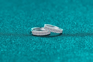 Close-up of S925 sterling silver hoop earrings featuring triple-row pave moissanite stones