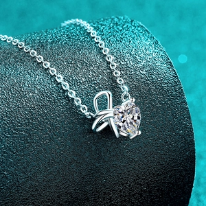 Halskette aus S925 Sterlingsilber mit Herz-Moissanit und Schleifen-Design auf dunkelgrün