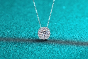 Gros plan du collier pendentif tournesol en argent avec moissanite et pierres baguette