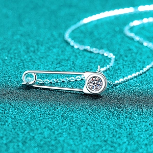 Collier épingle de sûreté en argent S925 avec pierre moissanite sur fond bleu texturé