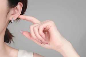 Close-up of S925 sterling silver moissanite hoop earrings worn on a model's ear