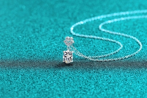 Makroaufnahme von ovalem Moissanit-Anhänger auf blauem Glitzergrund mit S925 Silberkette