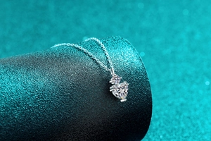 Vue macro du pendentif coeur en argent S925 et moissanite sur un support cylindrique