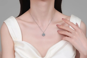 Gros plan du collier flocon de neige en argent S925 avec une pierre bleue sur modèle