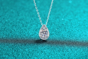 Macro shot of S925 silver pear-shaped pendant with round moissanite halo setting