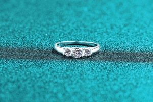 Macro view of a wave-designed S925 sterling silver ring with three sparkling moissanite stones