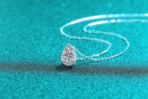 Macro shot of silver pear-shaped pendant featuring sparkling moissanite cluster inlay