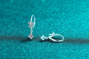 Macro shot of silver flower earrings with tassels and moissanite stones in claw setting