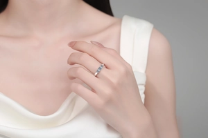 Close-up of S925 silver ring featuring three blue moissanite stones on a female hand