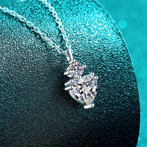 Collier en argent sterling S925 avec pendentif cœur en moissanite sur fond bleu canard