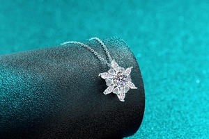 Macro shot of S925 sterling silver snowflake pendant with moissanite on a black stand
