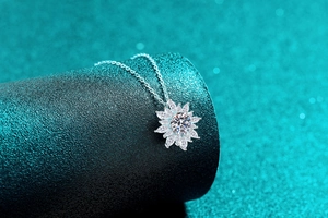 Vista macro della collana con ciondolo a girasole in argento e petali di moissanite