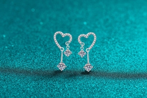 Dettaglio di orecchini a cuore in argento S925 con nappe in moissanite e pietre
