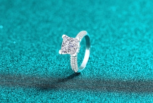 Vue macro d'une bague en moissanite taille princesse avec pavé de diamants sur argent