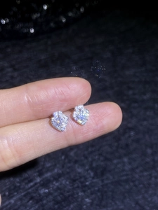 Macro shot of S925 silver heart stud earrings featuring moissanite pavé setting details