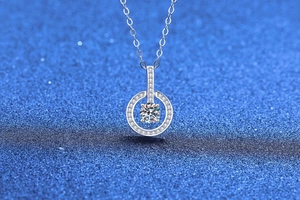 Macro shot of Moissanite necklace featuring a sparkling circular halo pendant with pavé stones