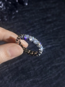 Macro shot of silver eternity band featuring sparkling round-cut stones in prong setting
