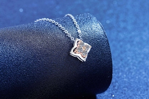 Macro detail of S925 silver four-leaf clover pendant with moissanite and rose gold accents