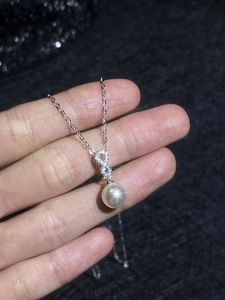 Detailed close-up of s925 silver infinity symbol necklace with moissanite and pearl
