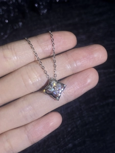 Macro shot of silver S925 four-leaf clover pendant with moissanite cluster shimmering on chain