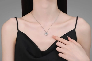 Close-up of S925 silver clover pendant with moissanite diamonds worn by a model