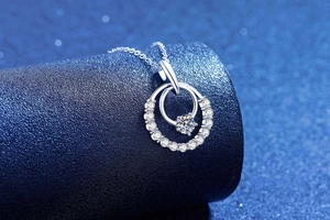 Macro view of interlocking silver rings pendant with sparkling moissanite diamonds