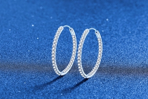 Vue détaillée de grandes créoles en argent 925 avec pavage de pierres en moissanite