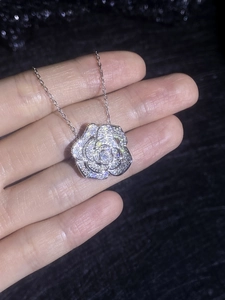 Détail macro du pendentif camélia en argent S925 avec sertissage complet de moissanite