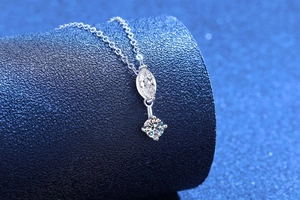 Detail of S925 silver necklace with marquise and round brilliant cut moissanite pendants