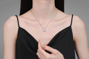 Close-up of S925 silver necklace with sparkling clover pendant worn by a model