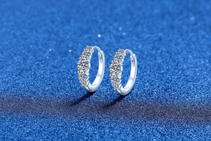 Macro shot of S925 sterling silver huggie earrings featuring five bright moissanite stones