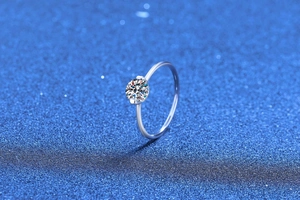 Macro detail of 1 carat moissanite ring with unique two-prong setting on silver band