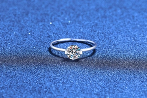 Macro shot of 1 carat moissanite ring with silver band showing fire and claw setting