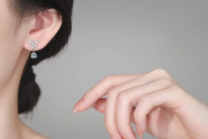 Vue macro de boucles d'oreilles nœud en argent s925 avec moissanite sur l'oreille
