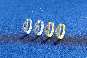 Vue macro de boucles d'oreilles créoles en argent S925 et or avec pierres de moissanite