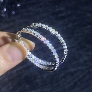 Créoles de luxe en argent 925 avec pavé de moissanite sur fond bleu étincelant