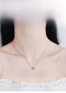 Close-up of a s925 silver necklace with a round moissanite pendant on a model