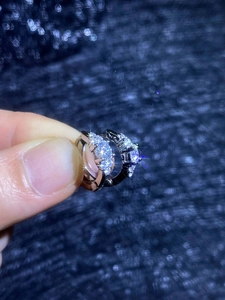 Gros plan de créoles en argent S925 et moissanite tenues à la main sur fond bleu