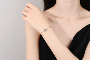 Detail of elegant six-prong moissanite diamond solitaire silver bracelet on female wrist