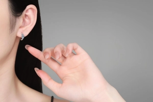 Gros plan de créoles en argent S925 avec moissanite portées à l'oreille d'un modèle