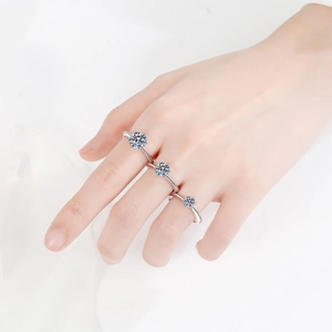Three 925 sterling silver rings with round moissanite stones in graduated sizes on finger