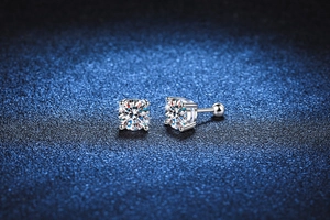 Macro λήψη από σκουλαρίκια moissanite 925 με βιδωτό κούμπωμα σε φόντο με μπλε αστραφτερή υφή