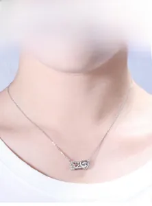 Close-up of 925 silver 520 heart pendant necklace with shimmering moissanite on a model
