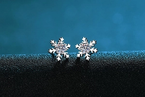 Macro shot of silver snowflake earrings with a centered round-cut moissanite stone